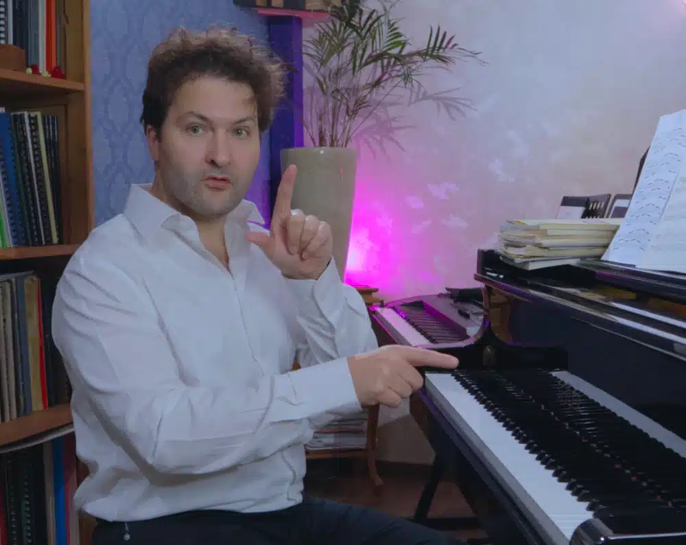 Lars Nelissen aan de piano uitleg aan het geven